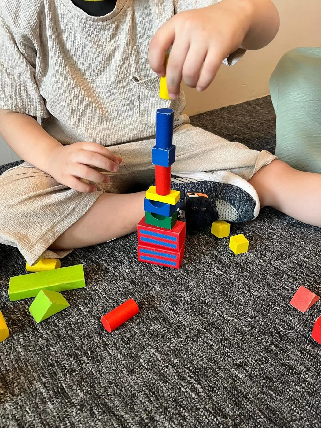 Renkli ahşap bloklarla kule kuran çocuk